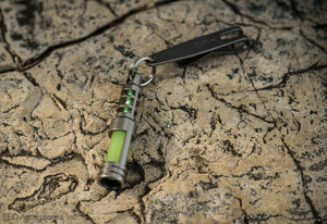 Isotope Chain Reaction Glow Fob on rock
